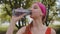 Athletic fit sport jogger young woman drinking water from bottle after training exercising in park