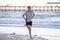 Athletic fit and strong runner man training on Summer sunset beach in sea shore running and fitness workout in sport and healthy l