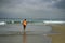 Athletic full body portrait of young attractive and fit black afro American man running on the beach doing Summer fitness jogging