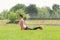 Athletic girl cobra stretch grass stomach facing floor