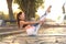 Athletic girl is doing advanced yoga asana on the fitness mat outdoors