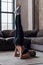 Athletic girl doing supported shoulder stand during yoga or gymnastics practice at home