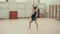 Athletic girl in the gym makes a somersault ahead, without touching