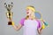 Athletic girl hold tennis racket and golden goblet. Win tennis game. Woman wear sport outfit. Tennis player win