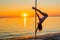 Athletic girl stands next to a portable pylon on the beach. Sand, sunset, beach.