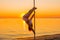 Athletic girl stands next to a portable pylon on the beach. Sand, sunset, beach.