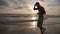 Athletic guy jogging along ocean shore during sunrise. Young sporty man running on the sea beach at sunset. Male