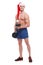 A athletic guy with a naked torso and a santa hat is standing with a dumbbell in his hands.