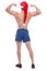 A athletic guy with a naked torso and a santa hat, stands with his back and shows his biceps.