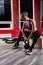 An athletic and happy young blonde female posing with atheltic training ropes and dumbbells in a gym.