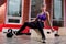 An athletic and happy young blonde female posing with atheltic training ropes and dumbbells in a gym.