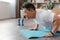 Athletic korean mature man doing push-ups on sports mat at home, working out core and hands muscles, copy space