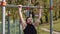 Athletic lebanese man in sportswear doing pull ups exercises on horizontal bar, pumping up back