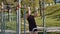 Athletic lebanese man in sportswear doing pull ups exercises on horizontal bar, pumping up back