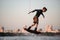 athletic male wakeborder masterfully jumping over splashing wave on wakeboard. Blurred background