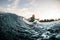 athletic male wakesurfer lying on the board rides down the river wave