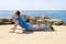 Athletic man doing stretching exercise, preparing for workout on seashore. Handsome fitness athlete doing a stretching routine.