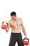 Athletic man holding and lifting up red kettlebells weights one