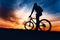 Athletic man on mountain bike against colorful sky