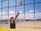 Athletic man passes the beachvolleyball