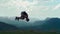 Athletic man performs a backflip stunt against a stunning mountain landscape