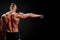 Athletic man posing. Photo of man with perfect physique on black background. Back view. Strength and motivation