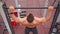 Athletic Man Pumps Up Muscles Doing Pull-Ups Open Sports Ground with Bare Torso