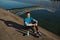 Athletic man runner sitting rests after training on city river bank