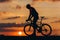 Athletic man in silhouette posing on camera with bike