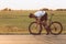 Athletic man tighten bolts on wheel of black bike