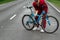 Athletic Man in a tracksuit holds a bicycle on his shoulders while standing on the road in the forest. The concept of a healthy