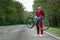 Athletic Man in a tracksuit holds a bicycle on his shoulders while standing on the road in the forest. The concept of a healthy