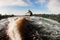 athletic man wakesurfer skilfully riding down the blue splashing wave on wakesurf