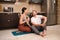 Athletic man and woman blogger in sportswear doing sports exercises at home in the kitchen together, resting after training. Stay