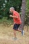 Athletic mature man jogging in forest
