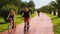 Athletic men and women riding a bike at beautiful green park, summer and sport