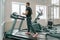 Athletic muscular bearded man running on treadmills in modern sport gym. Fitness, sport, training, people concept