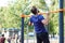 Athletic muscular sportsman trains on the horizontal bar