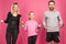 athletic parents and daughter in sportswear training with jump ropes, isolated