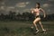 Athletic runner Asian woman training running series workout working hard outdoors on field background in harsh contrast light spor