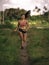 Athletic runner Asian woman training running series workout working hard outdoors on field background in harsh contrast light spor