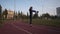 Athletic senior female doing physical exercise with stick on running track stadium before training Nordic walking