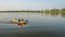 Athletic, senior man is paddling a prone kayak