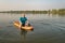 Athletic, senior man is paddling a prone kayak