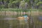 Athletic, senior man is paddling a prone kayak