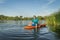 Athletic, senior man is paddling a prone kayak