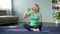 Athletic senior woman sitting on floor and drinking water after workout, health