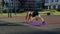 Athletic slender girl in black tight uniform does plank run on street on sports ground in residential complex with