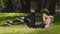 Athletic slender strong caucasian woman trainer female lady lies on mat on grass outdoors in park bends legs and body