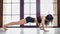 Athletic sport young curly woman showing push ups exercise on mat at gymnastic studio